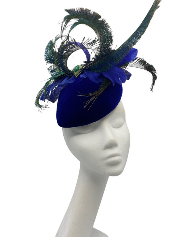 Royal blue velvet teardrop base with an array of peacock feathers and a green jewelled detail to the centre.